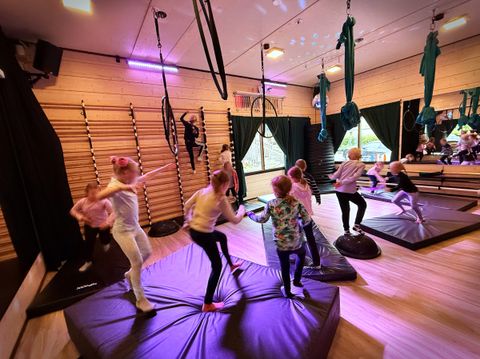 Tunnelmakuva lasten ilma-akrobatiasynttäreiltä. Käynnissä alkuleikki, jossa lapset juoksevat patjoilla ja leikkivät hippaa..