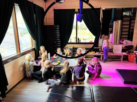 Lapsia istumassa pöytänä toimivan patjan ympärillä synttärijuhlissa. Lapset nauttivat erilaisia tarjoiluja.